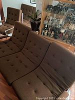 Overhead view of three-seat sofa and two matching chairs with chocolate brown tufted cushions on chrome frames