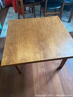 Full view looking down on the vintage teak coffee table showing the square top and legs.