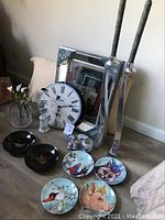 Full lot photo showing 4 animal plates, 2 Couroc bowls, Delft clock, mirror, and 2 silver candlesticks.