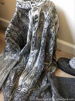 Tall charcoal mukluk shoes with vibrant sneaker-style soles and gray denim jacket with floral embroidery.