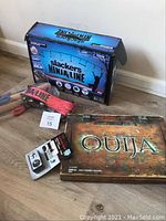 Slackers Ninja Line box next to Ouija board and compass clock on the floor