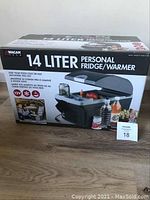 Front view of box showing product name and image of personal fridge/warmer with food and drinks inside.