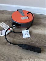 Full view of the Bayco Model 800 electrical cord reel showing the orange and gray body with attached black cord and outlet.