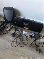 Photo showing Sirius Satellite Radio unit with attached speakers and several cables on the floor