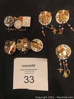 Full set on black background showing pin, earrings, hair clip, and button cover with mechanical gear and watch face theme.