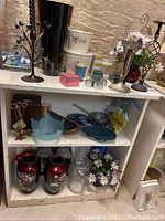 Small white painted bookcase holding various vases and decorative items, showing worn condition and paint chipping; items shown are not included in the lot.