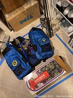 Photo of blue diving bags with flippers and snorkels plus fishing poles in corner of room