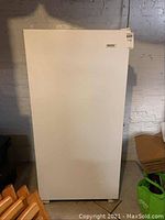 Front view of white upright freezer showing plain exterior and overall condition.