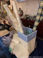 Photo of fabric hampers filled with rolled fabrics and quilt pieces in a basement setting