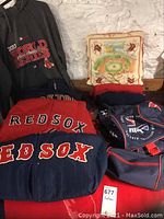 Photo showing 2013 World Series sweatshirt, travel bags, Red Sox blanket, and vintage Fenway pillow.