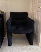 Front view of a black microsuede arm chair showing its squared arms and cushioned seat and back.