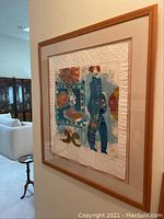 Framed relief print viewed at angle against wall