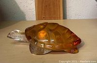 Side view of the amber and clear crystal turtle figurine showing amber shell and clear crystal head and legs.