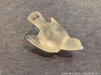 Top and side view of frosted Lalique crystal sparrow showing detailed feathers and bird shape.