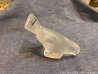 Front angle view of frosted crystal sparrow figurine on fabric background.