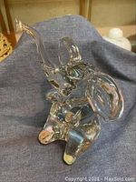 Front view of signed Daum crystal elephant figurine with raised trunk and large ears.