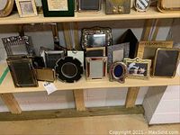 Right half of bottom shelf displaying an assortment of picture frames in various sizes and materials.