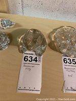 Photo of Baccarat crystal frog figurine viewed from front, showing clear crystal shape and stamped label underneath.