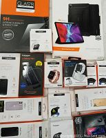 Complete overview of all Spigen items in the lot spread on a flat surface, showing boxes for phone cases, iPad case, Apple watch bands, and screen protectors.