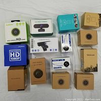 Overview of 12 boxed webcams from multiple brands including Ausdom, Papalook, Anivia, generic units