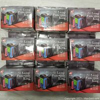 Nine boxed Bicycle Lamp Function King units stacked in three rows, showing packaging and branding.