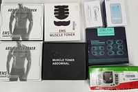Overview of multiple EMS muscle toner boxes and TouchCare unit on white background