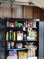 Shelf with multiple car care products including waxes, polishes, sprays, and automotive accessories.
