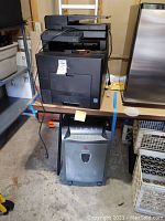 Photo showing Dell C3765dnf printer/copier stacked on a stand with a Xerox-branded paper shredder below it.