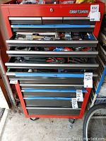 Full view of the Craftsman toolbox with drawers partially open showing various household repair items and tools inside.