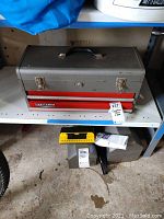 Gray Craftsman toolbox with black handle and two red drawers sitting on shelf, showing overall condition and presence of tools inside