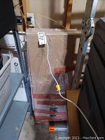 Photo of packaged Target Threshold 6-cube organizer unit wrapped in plastic with red tape, in storage area.