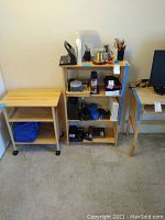 Light wood bookshelf with items on shelves beside light wood printer cart on caster wheels