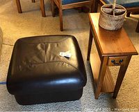 Photo of brown leather-like IKEA ottoman and wood side table together showing overall appearance and scale.