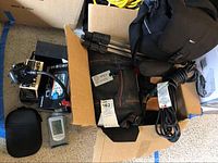 Overview of black camera bags, Slik U6000 tripod, power cord, mount and small digital device