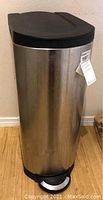 Full view of Simplehuman stainless steel tall trash can showing black lid and step pedal