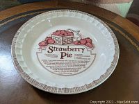 Top view of the front of the pie plate showing the strawberry pie recipe and illustration.