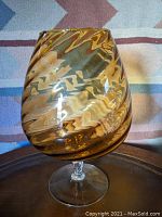 Large amber swirl Empoli snifter shown from front, highlighting swirl pattern and bowl shape.