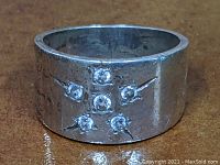 Front view of the sterling silver wide band ring showing six stones arranged in a cross pattern.