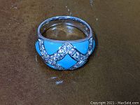 Top view of sterling silver ring with turquoise inlay and crystal zigzag decoration.