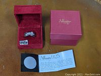 Ring displayed in red velvet inner box with outer box and paperwork
