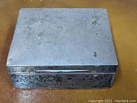 Top and sides view of an antique sterling silver box showing tarnish and surface marks.