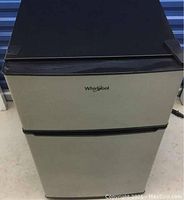 Front view of stainless steel Whirlpool mini fridge with black trim and two-door design.