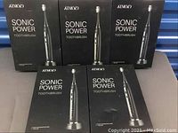 Five boxes of Sonic Power Toothbrush in black stacked, showing front packaging with toothbrush image and brand logo