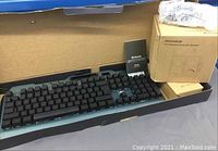 Wireless keyboard and mouse in open box, includes setup guide with Mandis branding.