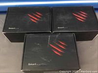 Three Smart Box Me 4K Android TV boxes in their closed black packaging with red claw marks logo.