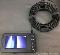 Digital endoscope camera with screen turned on, showing live video feed, connected to a long black cable.