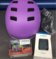 Photo showing purple bike helmet, bike light box, and bike stopwatch in original packaging