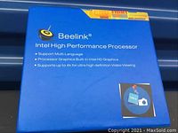 Blue Beelink Intel processor box showing branding and key specifications including multi-language support and 4K video
