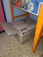 LG 5000 BTU room air conditioner inside sealed original box showing packaging details and shipping labels.