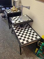 Full view of the two matching side tables showing the checkerboard tile tops and black frames.
